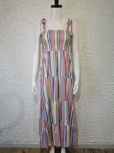 Detail view of colorful striped dress featuring tiered skirt and tied bow shoulder straps
