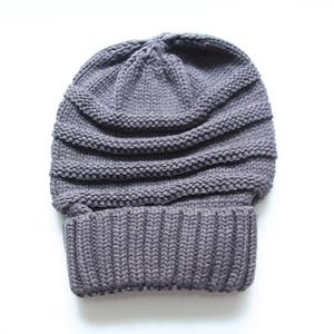 Close-up of deep grey chunky knit beanie showing ribbing texture and warm material