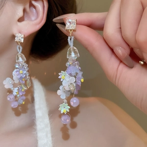 Detail of floral tassel earrings with lilac resin petals and clear crystal pendants