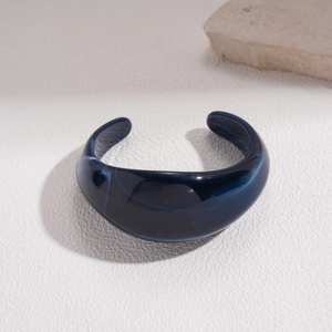 Detail shot of wide cuff bracelet featuring deep blue marble resin texture and high polish