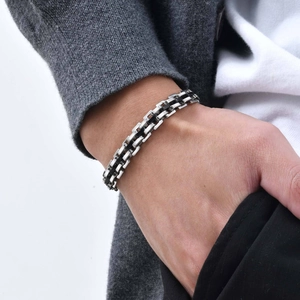 Close-up of men's stainless steel watchband-style bracelet with silver and black links