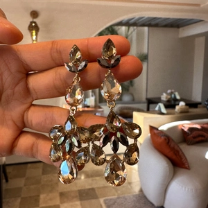 Detailed macro view of champagne teardrop fringe earrings with sparkling inlaid gems