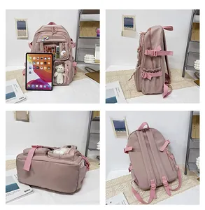 Detailed view of pink waterproof nylon backpack with transparent pocket and cute accessories
