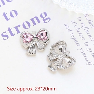 Detailed view of silver bow charm with pink crystal hearts and size dimensions