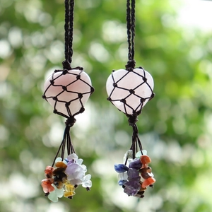 Detail of rose quartz heart pendant with colorful stone tassels and woven black rope