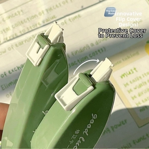 Primo piano del nastro correttore verde con design a flip-top su sfondo di note