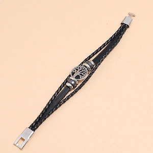 Detailed shot of multi-layer braided leather bracelet featuring a silver Tree of Life charm