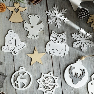 Nordic wooden Christmas ornaments with owl and angel designs on a gray wood surface