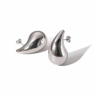 Macro shot of silver hollow teardrop earrings with a polished mirror finish and smooth metal