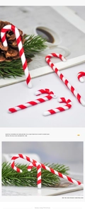 Detailed view of red and white striped Christmas candy cane ornaments on pine branches