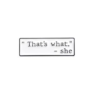 Detailed macro shot of white enamel speech bubble pin with 'That's what' text engraving