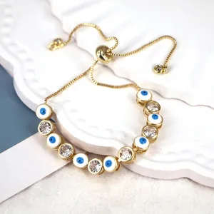 Adjustable gold evil eye bracelet with white enamel beads and sparkling zircon stones