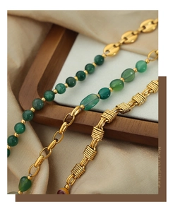 Detailed macro view of vintage gold-plated braided chains with green agate stones