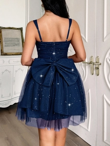 Detail of elegant dark blue evening dress featuring a large back bow and sparkly fabric