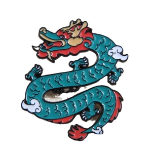 Creative turquoise enamel dragon brooch with gold and red details on white background