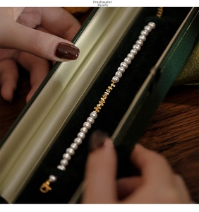 Close-up of elegant freshwater pearl bracelet with gold accents in green velvet jewelry box