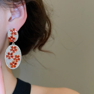 Close-up of vintage oval drop earrings with zircon flowers on a female model