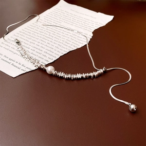 Detailed macro shot of Baroque pearl and silver snake chain with textured metal beads