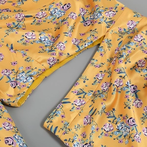 Detail shot of yellow floral print fabric with high-quality stitching and satin texture