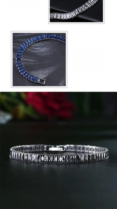 Macro detail of tennis bracelets in blue, black, and white zircon on a black mirror surface