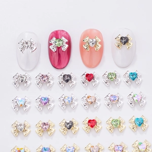 Detailed view of colorful heart crystal bow nail charms with gold and silver alloy frames