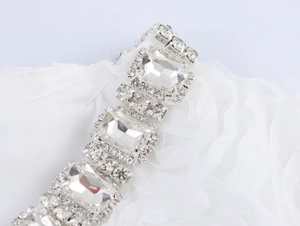 Détail macro d'une chaîne élégante en strass cristal sur un tissu en maille blanche
