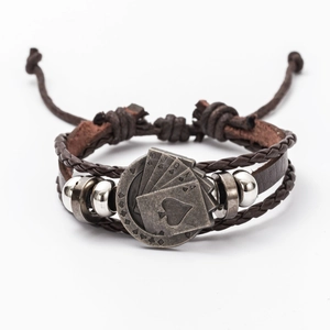 Macro detail of men's retro braided leather bracelet with alloy playing card charm