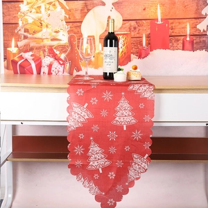 Détail du chemin de table de Noël rouge avec flocons blancs et décor festif