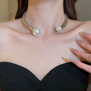 Close-up of minimalist silver metallic choker necklace with two large pearls on the model