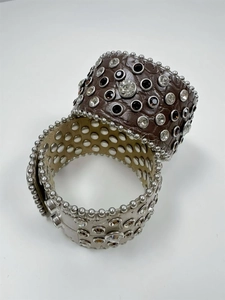 Detail of wide leather bracelets with silver rivets and multi-sized rhinestone inlays