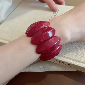 Close-up of red marble pattern acrylic resin stretch bracelet on a female wrist