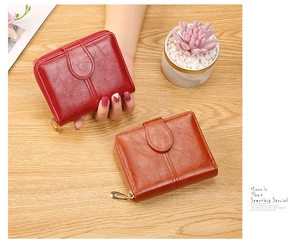 Close-up of polished faux leather women's zip wallet in red and brown colors