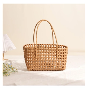 Detail of light brown woven plastic shoulder bag with hollowed-out texture and slim handles