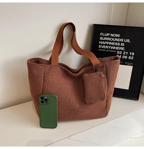 Close-up of brown waffle textured tote bag with a matching coin purse and phone for scale