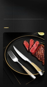 Detail of silver stainless steel knife and fork with luxurious gold diamond pattern handles