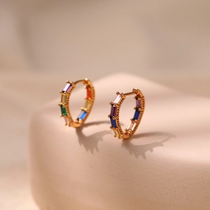 Detailed macro view of 18K gold plated huggie earrings with rainbow zircon stones