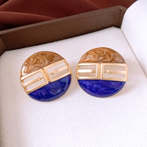 Detail of vintage round enamel earrings with brown and blue marble texture in jewelry box