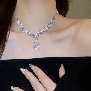 Luxurious V-shaped silver necklace with teardrop zircon crystals on a model's neck