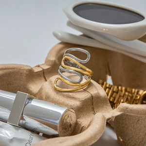 Minimalist multi-layer wavy ring with gold and silver dual-tone finish on brown tray