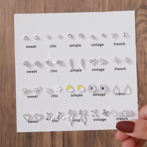 Détail de l'ensemble de boucles d'oreilles avec perles et coeurs sur carte blanche