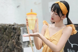 Outdoor detail of ice cream shaped gradient water bottle with matching carry strap and straw