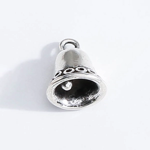 Detailed macro view of vintage silver bell pendant with textured wave pattern and ring