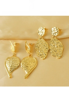 Detail of hammer-textured irregular leaf earrings in gold-plated titanium steel
