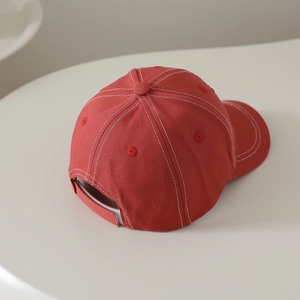 Top view showing red canvas baseball cap with white contrast stitching and adjustable strap