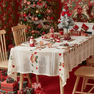 Beige Christmas tablecloth with red bell embroidery and lace edges in festive room decor