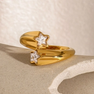 Macro detail of gold wrap ring with star-shaped cubic zirconia on stone background