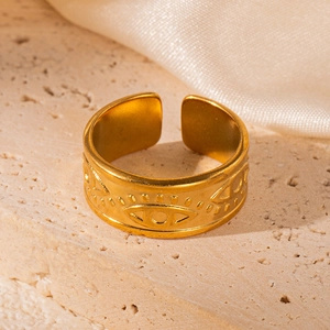 Macro detail of 18K gold-plated stainless steel open ring with embossed eye pattern on stone