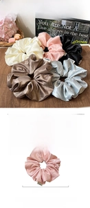 Detail showing oversized satin floral scrunchies with 19cm diameter and premium fabric texture