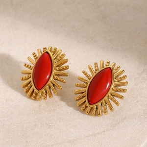 Detailed macro view of vintage gold stud earrings with marquise red stone sunburst design