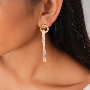 Close-up of elegant gold long fringe earrings with clear zircon stones on a model